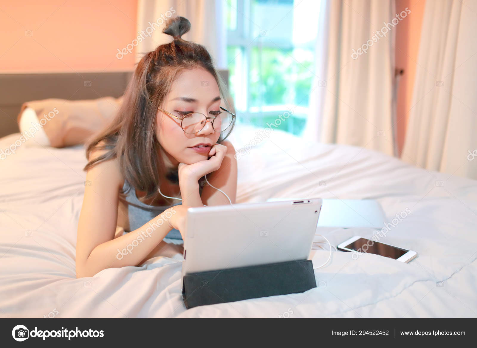 Young attractive businesswoman in glasses writing in a red notepad, sitting in front of the laptop in a cafe. 4